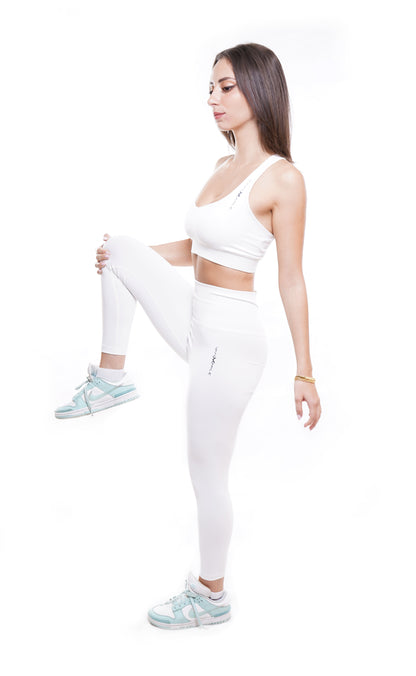 Women's VAN MILE Essential Leggings in White – side view in a quad stretch, shown with matching sports bra