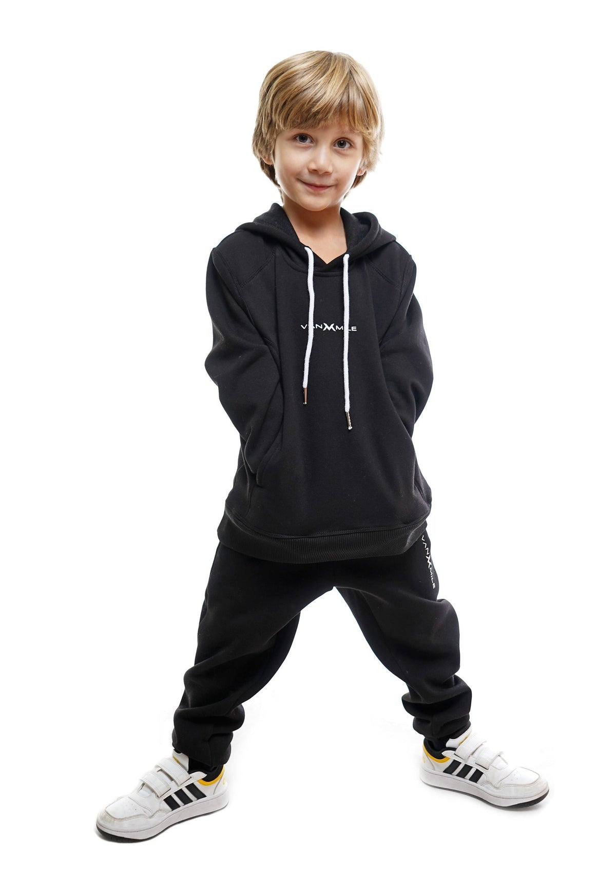 Kids' VAN MILE Everyday Kids Tracksuit in Black – front view, worn by a boy, hands in pockets
