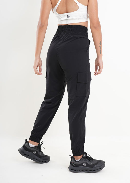Person wearing black cargo pants and black shoes on a white background