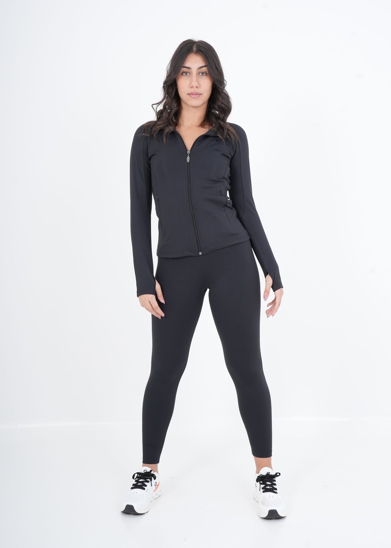 Woman wearing a black athletic outfit on a white background