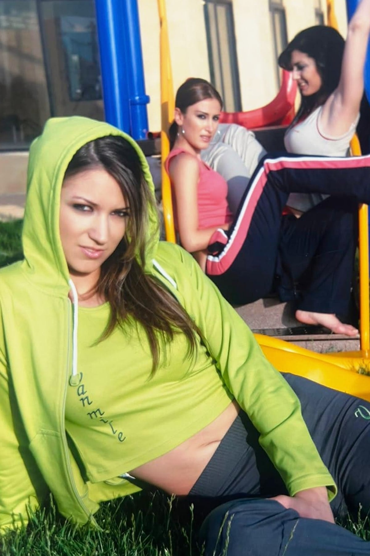 Archive VAN MILE photo: a woman in a lime VAN MILE hoodie and crop top, two women in VAN MILE training wear behind her